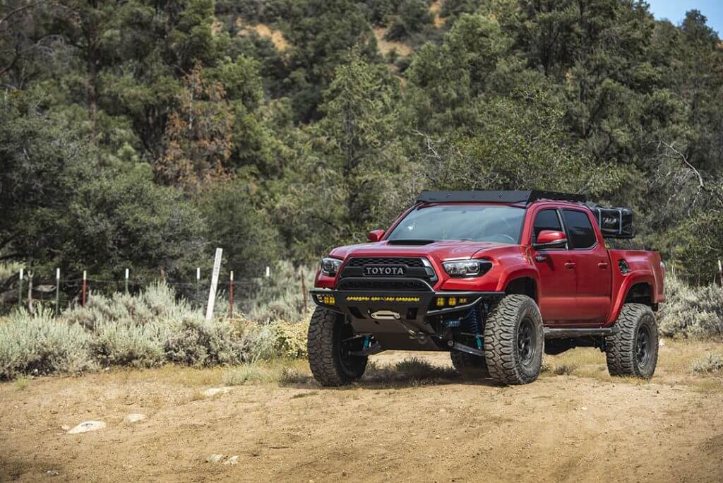 Red overland toyota tacoma with 35 inch Patagonia MT offroad tires