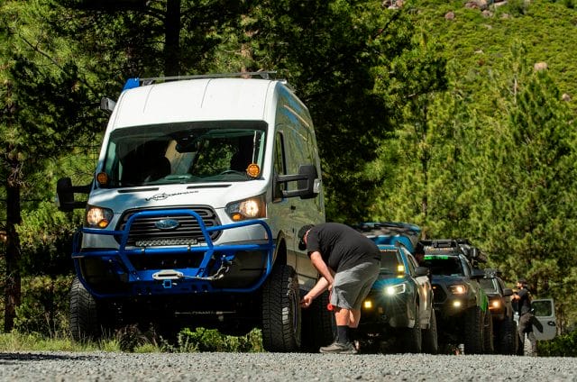 Ford transit van on milestar X/T tires followed by a blue subaru wilderness and a toyota tacoma