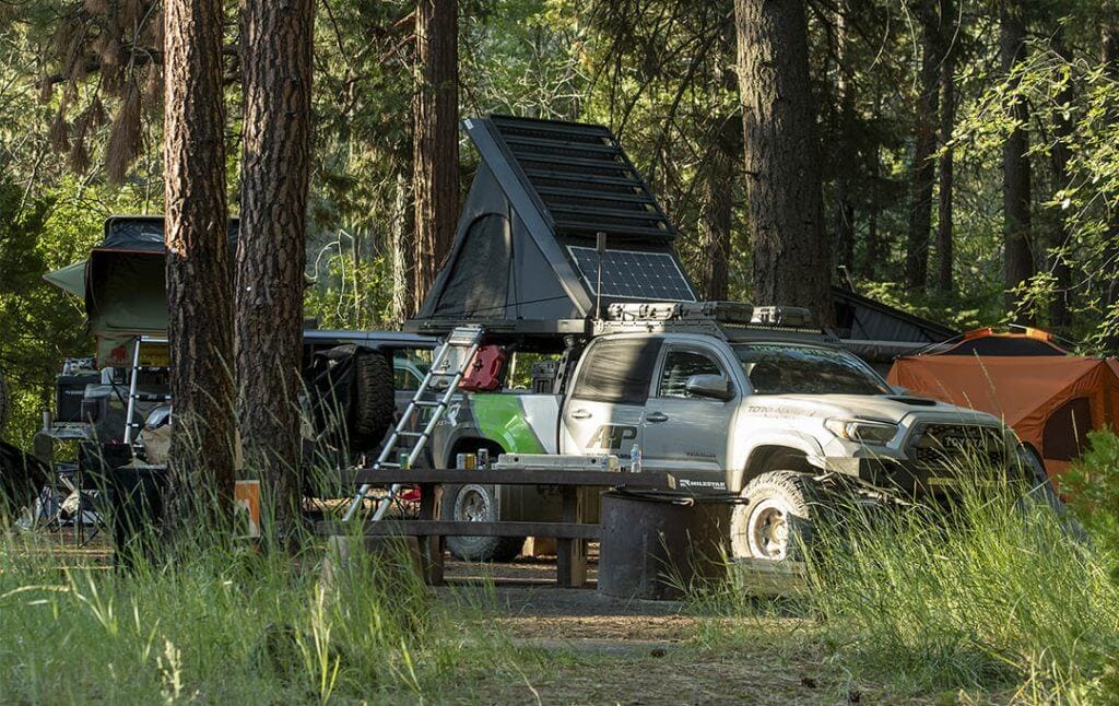 gray toyota tacoma overlander set up to camp