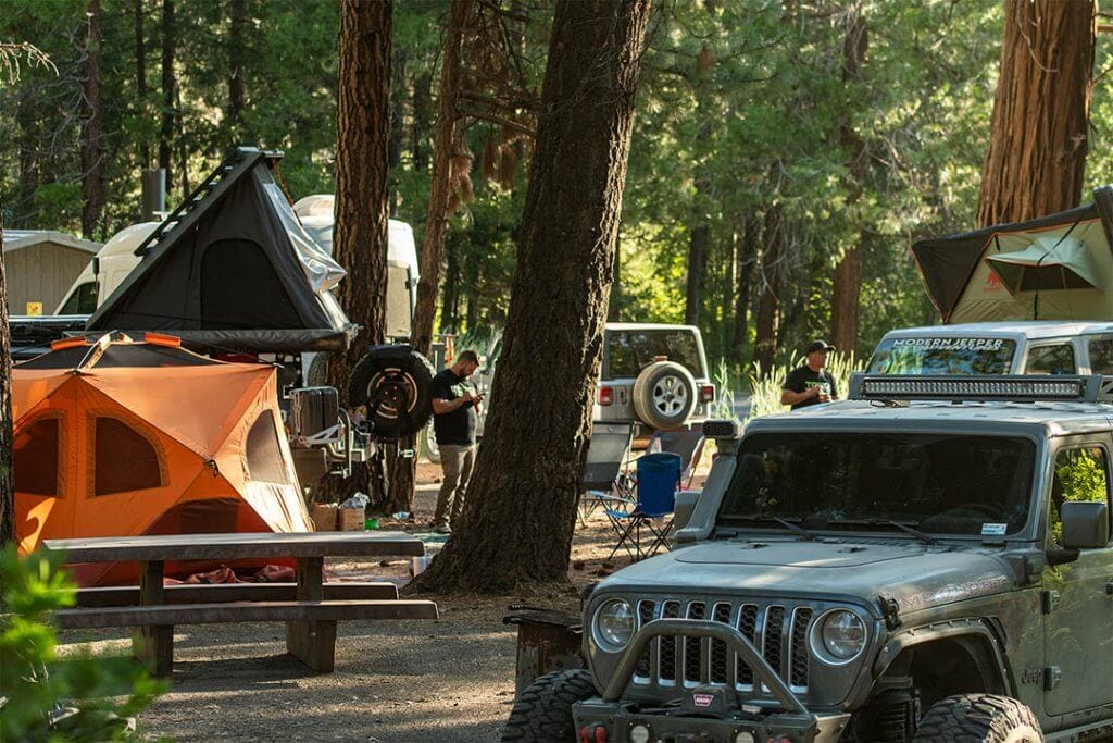 gray and white jeep overlanders set up camp